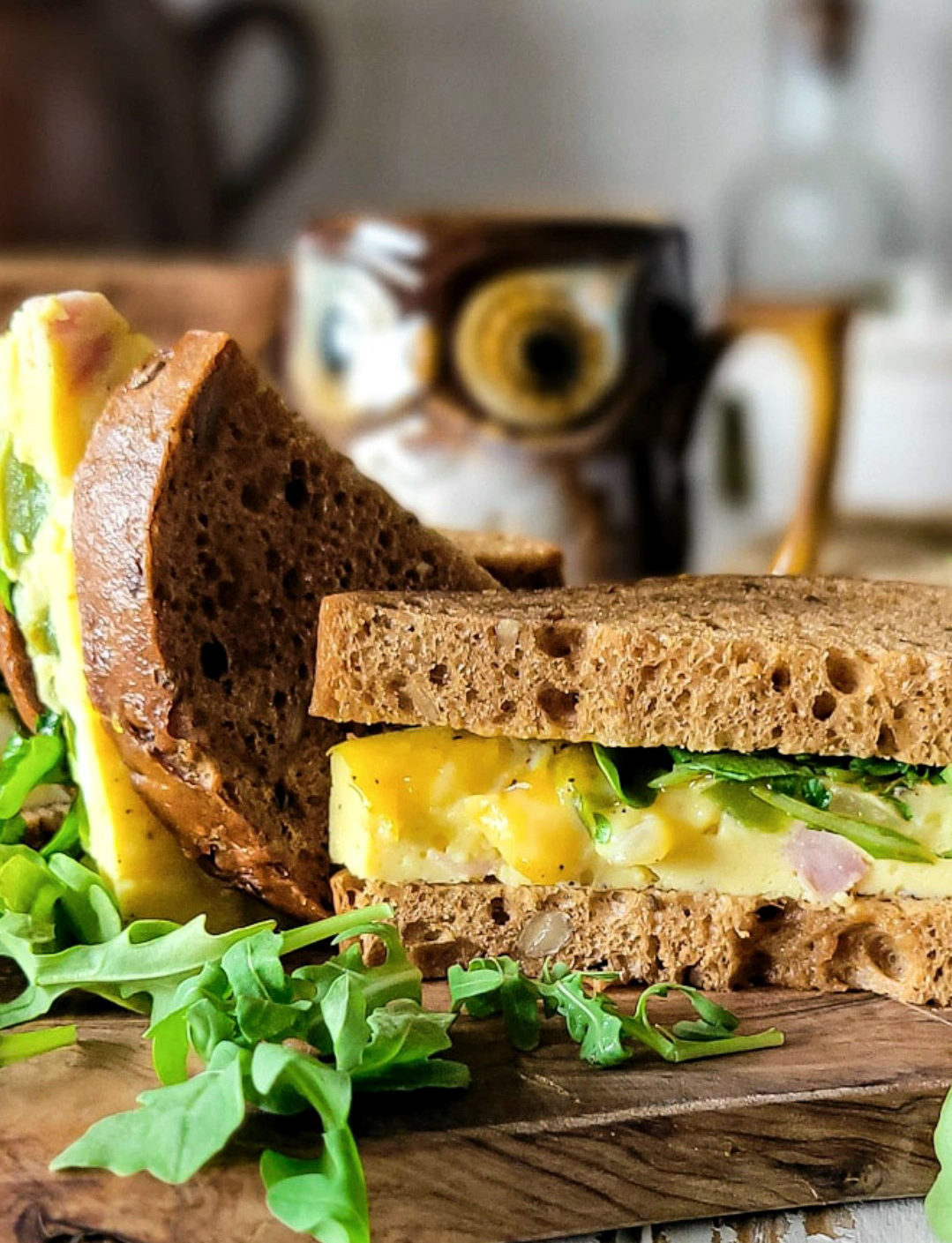 Close up of a Toasted Western Sheet Pan Sandwich, with a mug of coffee in the background.