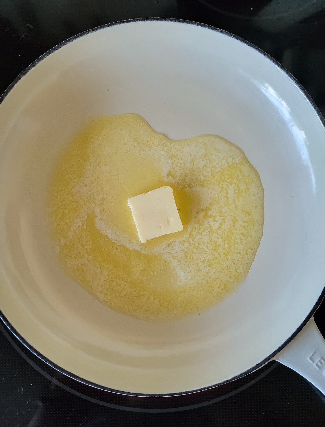 A skillet with butter melting in it to make Brown butter Bean and Kale pasta.