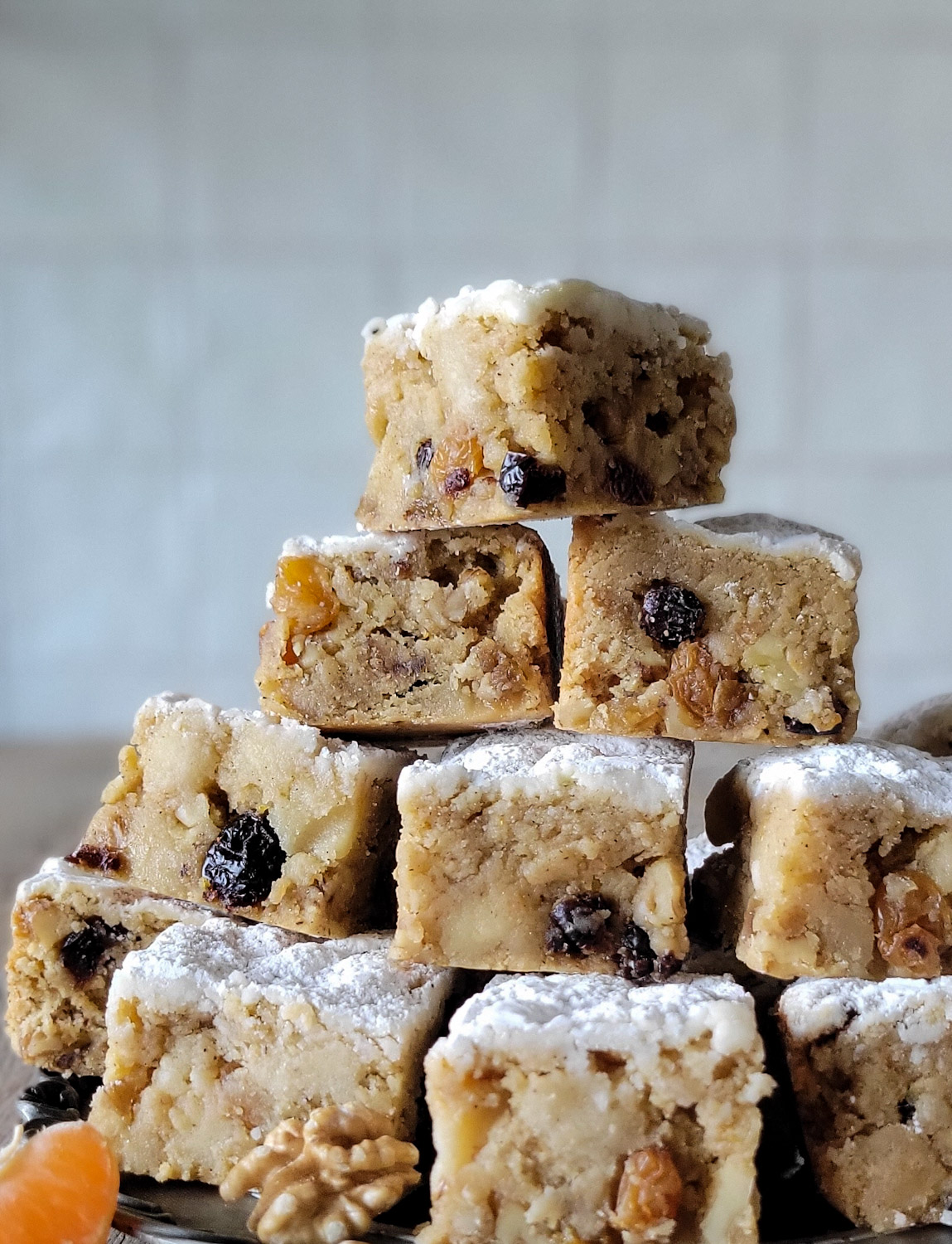 Close up of Stollen Blondie squares piled up, dusted with icing sugar.