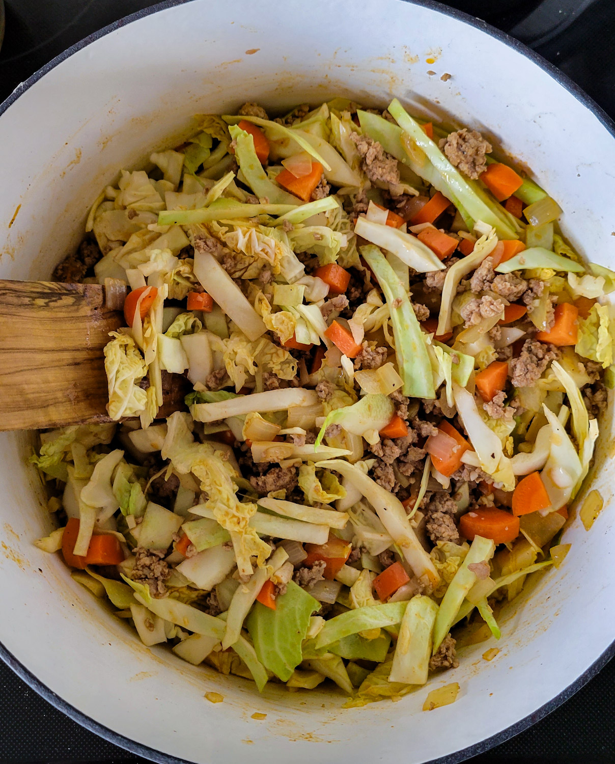 A pot with the beginning of Cabbage Roll Soup sautéing on the stove.