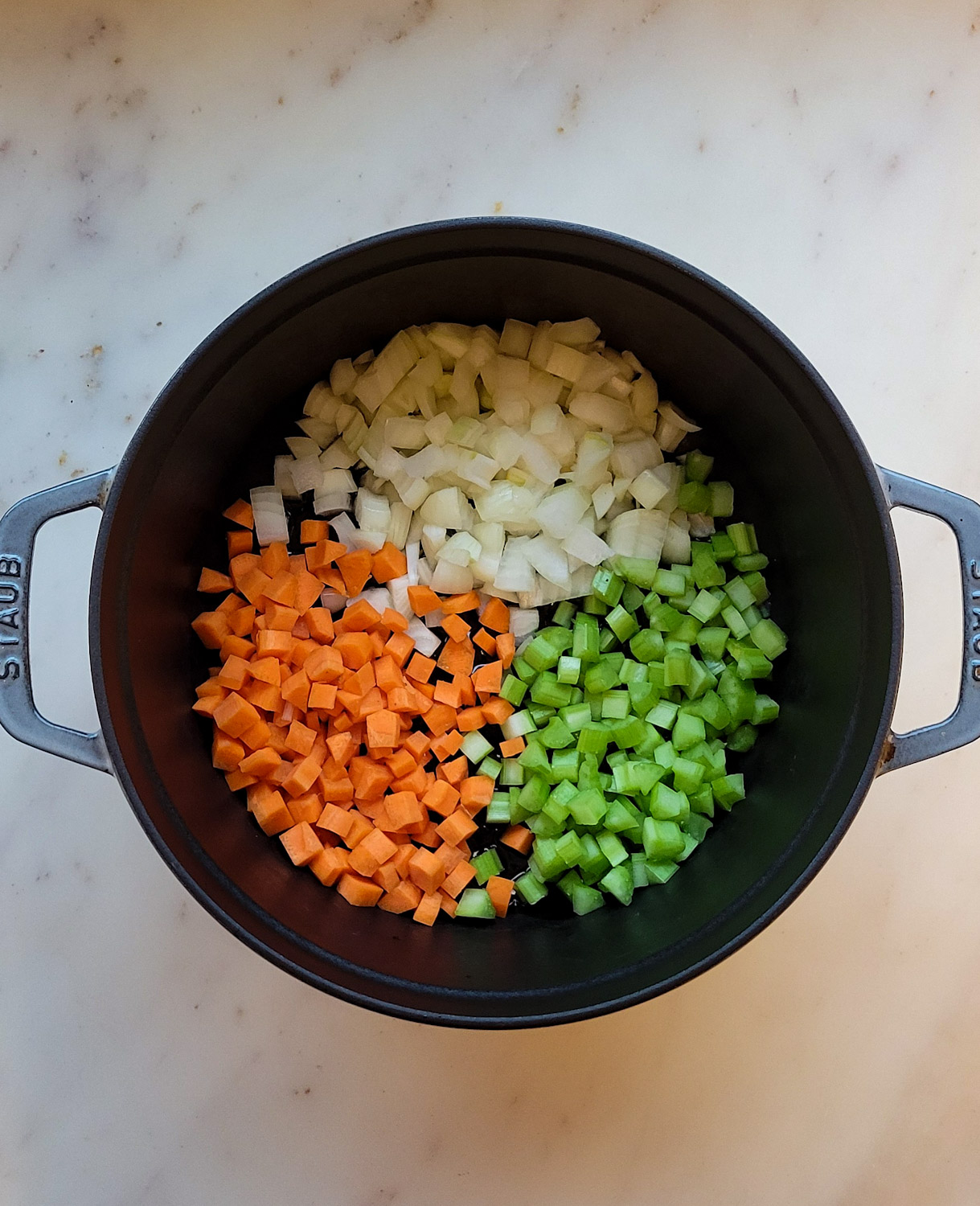 a pot filled with carrots, onions and celery, the base for Meatball Soup.