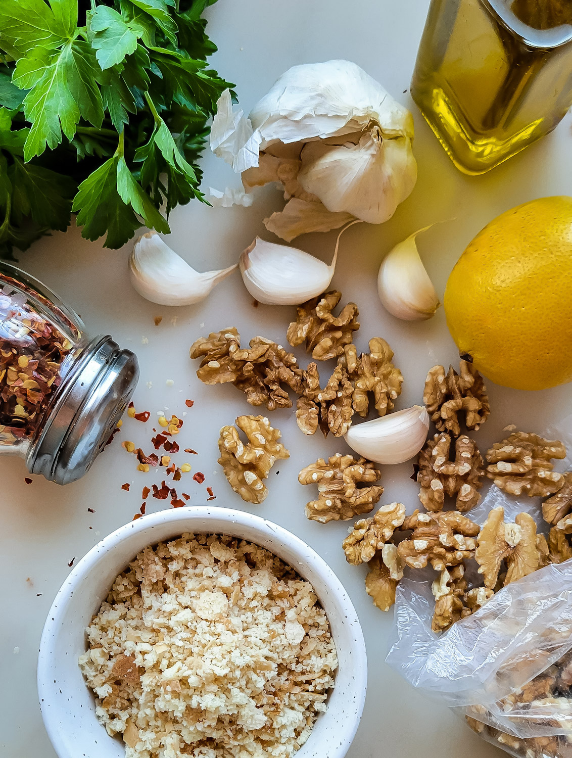 Ingredients for Walnut Pangrattato, garlic, lemon, walnuts, breadcrumbs, chilli flakes and parsley.