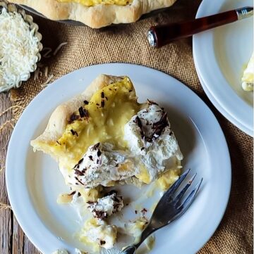 A slice of Black Bottom Coconut Cream Pie half eaten, more pie in the background.