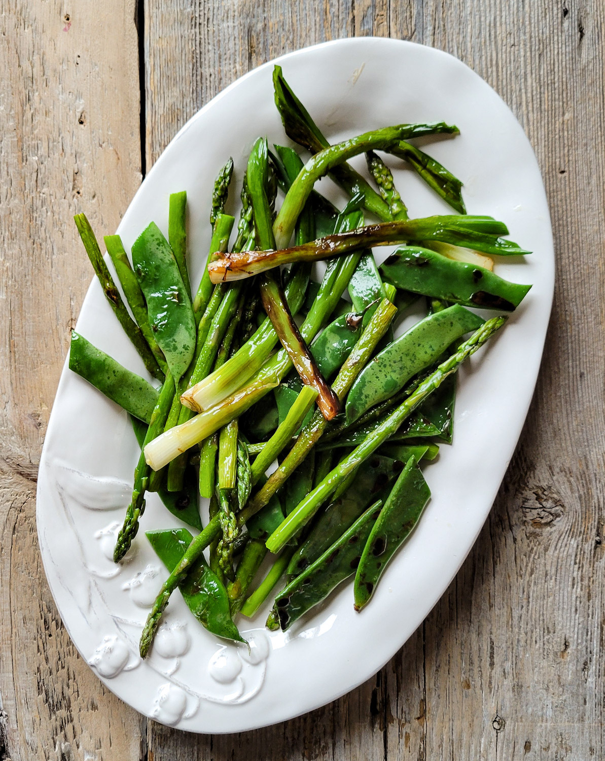 A plate filled with charred spring vegetables for the One Pot Spring Chicken and Orzo meal.