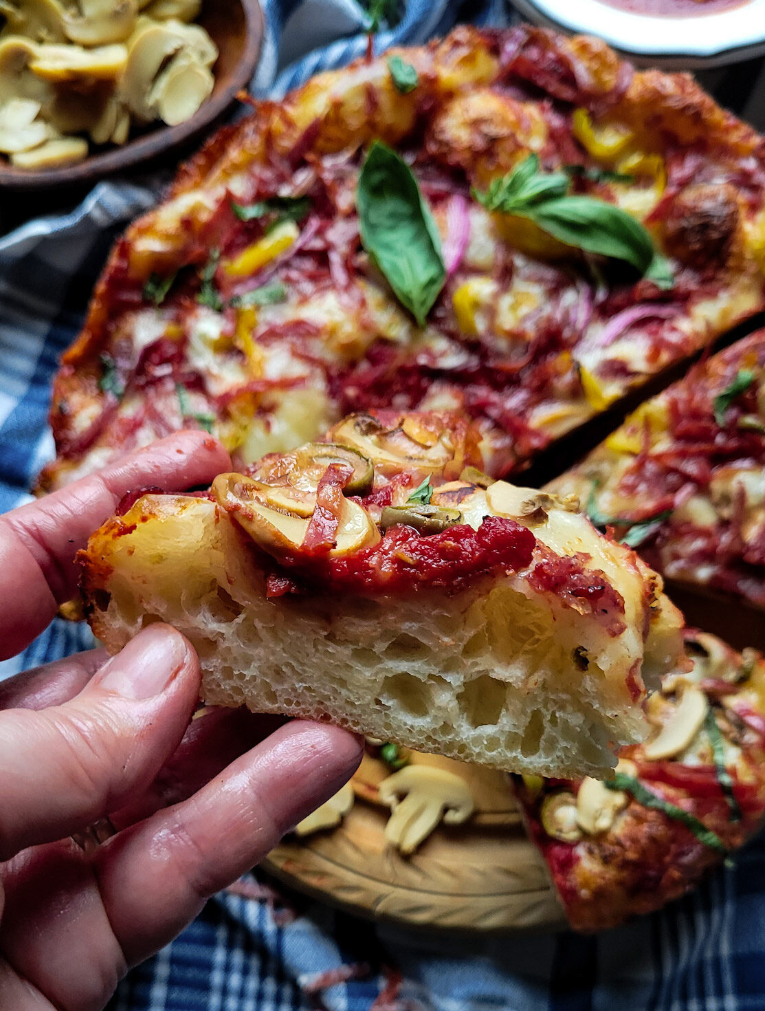 Close up of a slice of Windsor Style Skillet Pizza showing the rise and chewy dough.