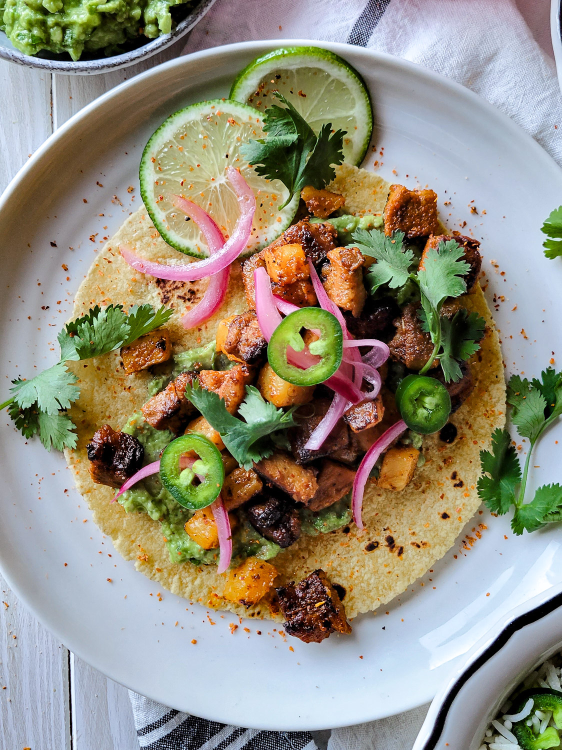 Al Pastor Pork and Pineapple taco with cilantro, pickled red onion and jalapeño pepper.