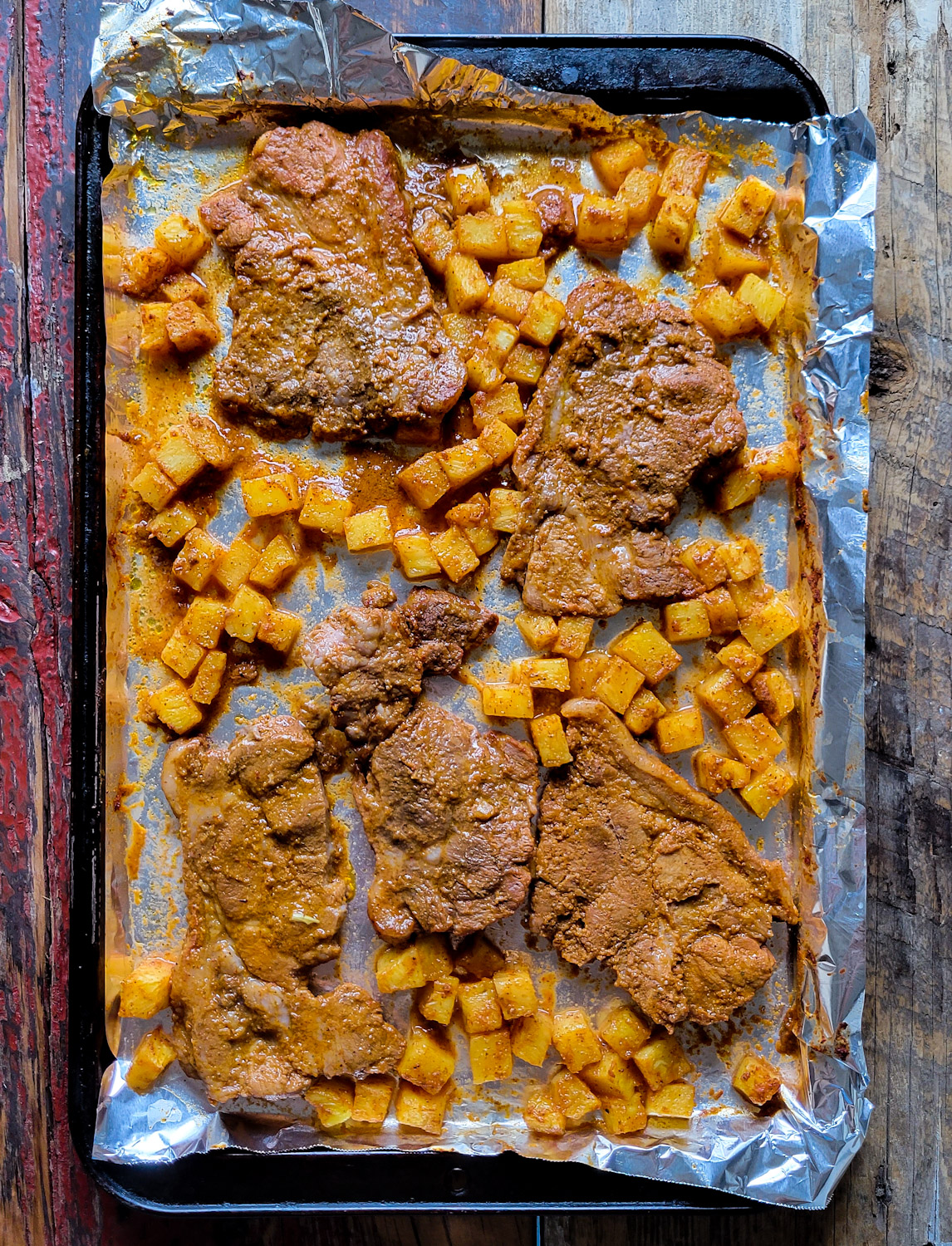 Al Pastor Marinated Pork and Pineapple spread out on a Baking sheet.