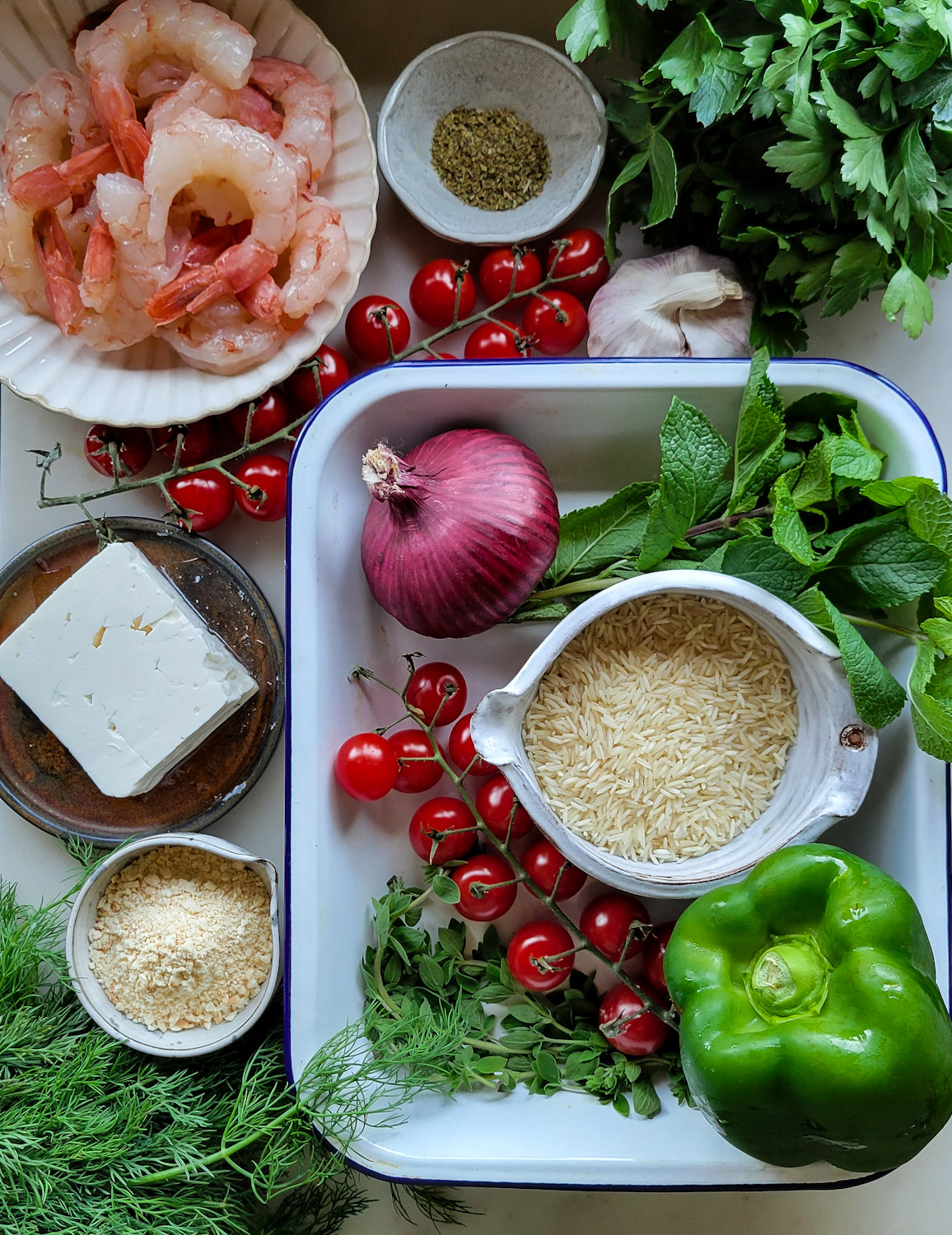 The ingredients needed to create a Mediterranean Shrimp and Rice Bake are set out on the counter.