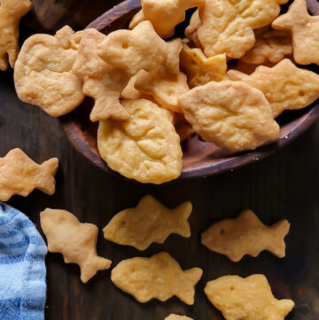 Close up of gluten free goldfish, as well as other shapes in a wooden bowl.