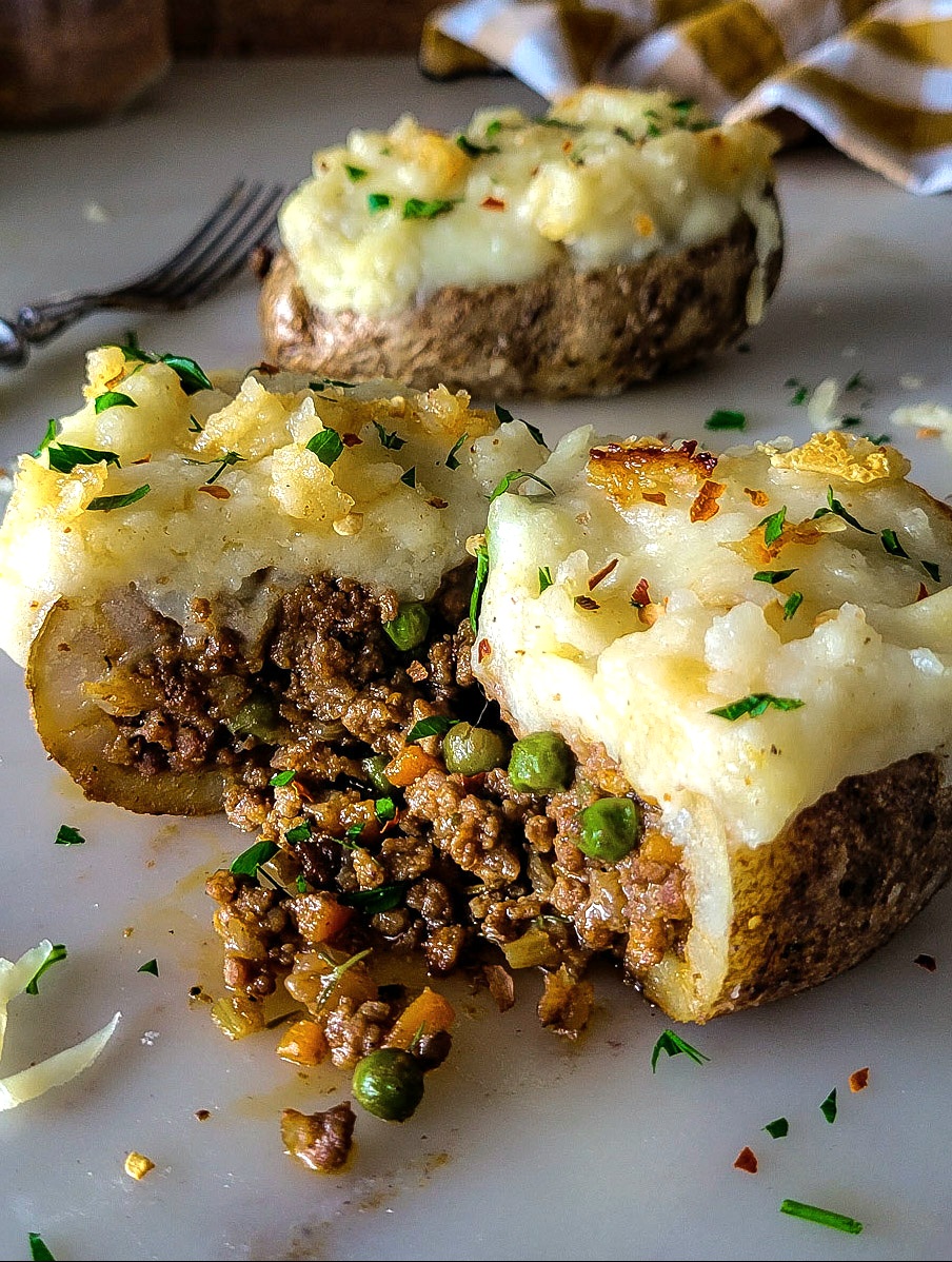 A Shepherd's PIe Stuffed Potato has been sliced open to reveal the meat and vegetable filling.