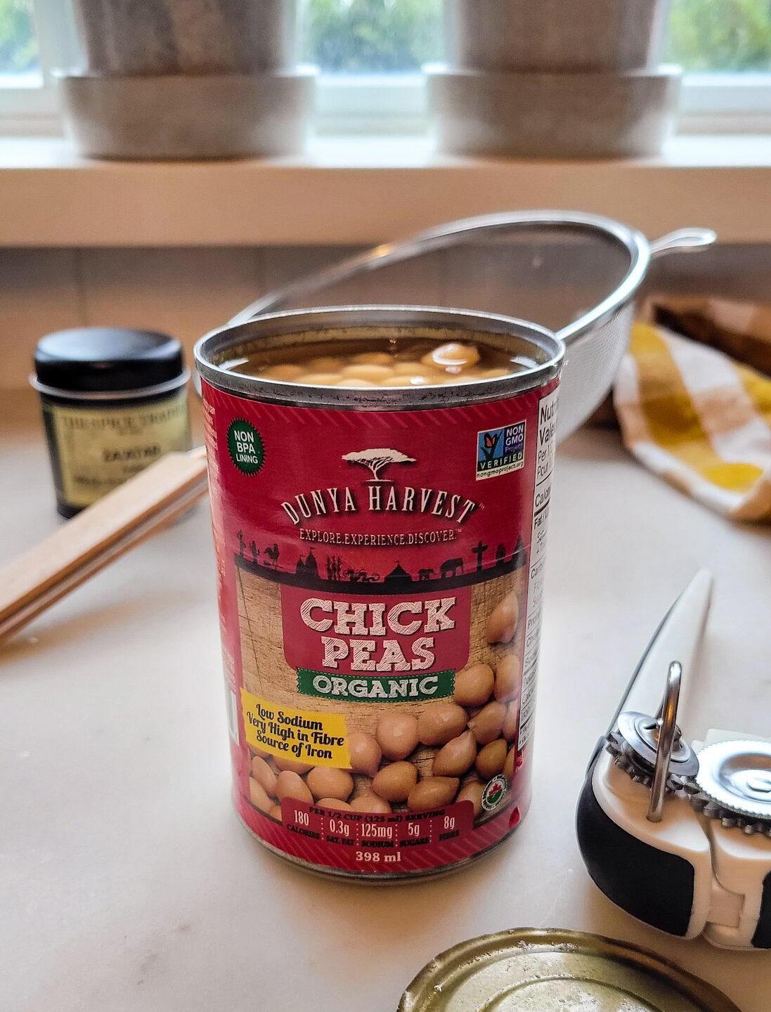 A can of Chickpeas is open, with the can opener to the side, getting ready to be used to make Dukka Roasted Chickpeas.