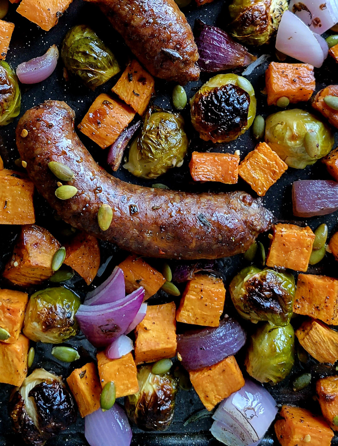 A baking sheet filled with roasted Autumn Vegetables and Sausages.