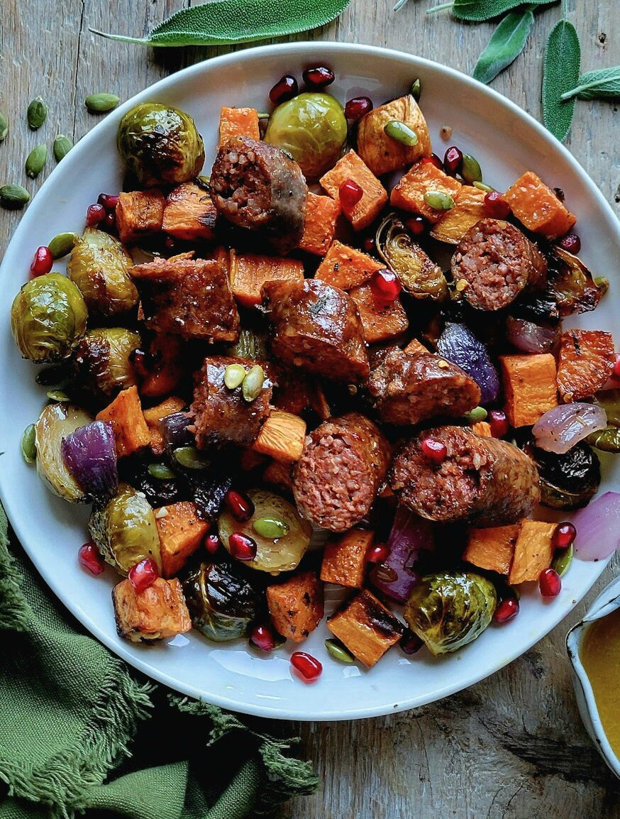 A plate filled with Roasted Autumn Vegetables and Sausages with a Maple Vinaigrette.