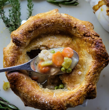 Close up of the baked Sage and Cider Turkey Pot Pie with a spoonful of the filling sitting on the crust.
