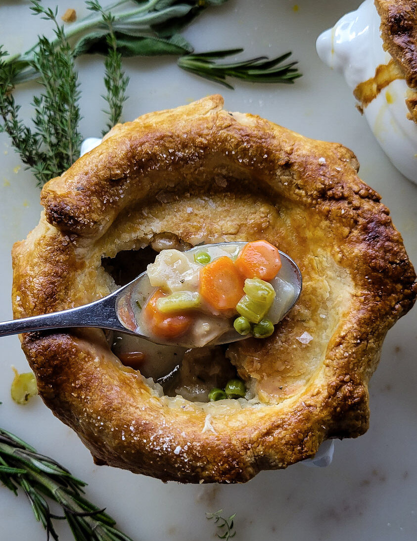 Close up of the baked Sage and Cider Turkey Pot Pie with a spoonful of the filling sitting on the crust.