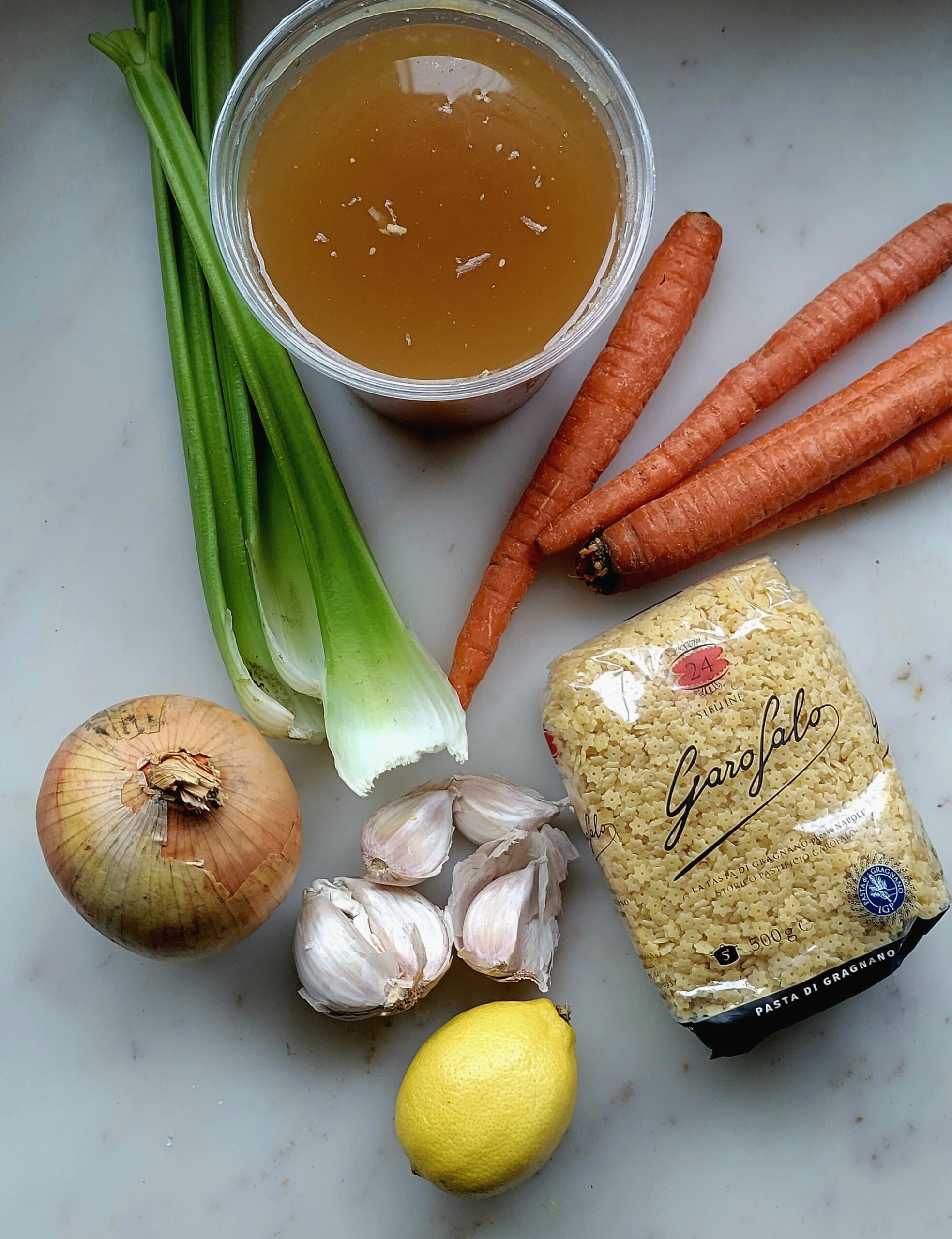 Ingredients needed to make a pot of Pastina spread out on the counter.