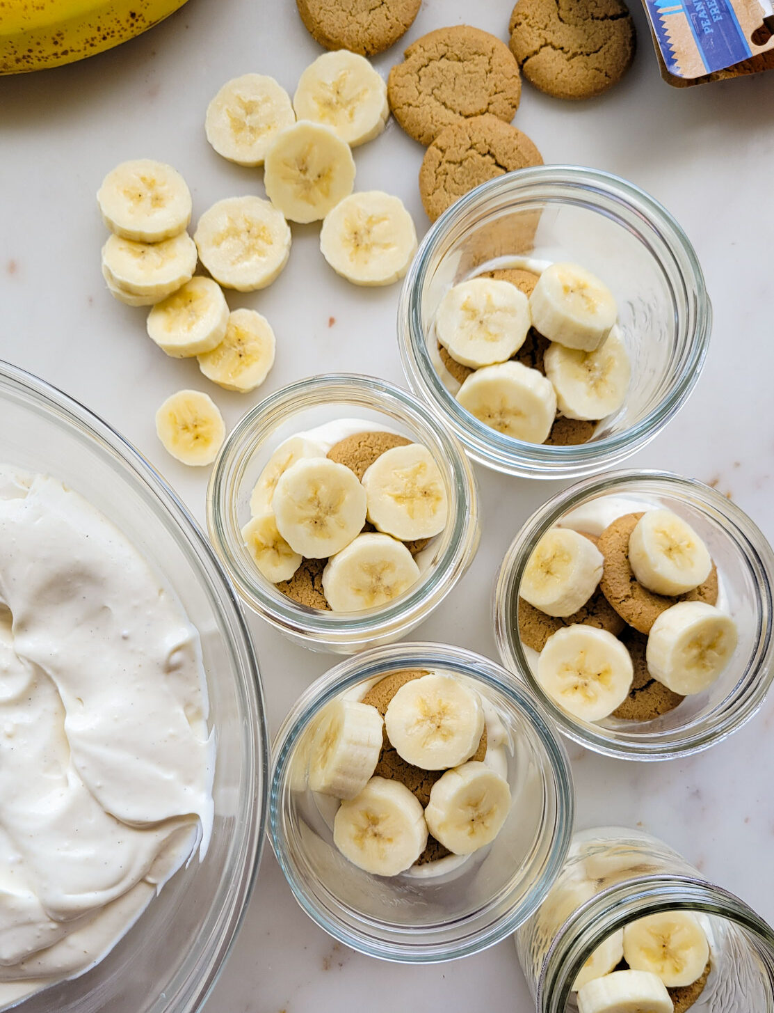 Looking down on the sliced banana layer in mason jars for Classic Banana Pudding.