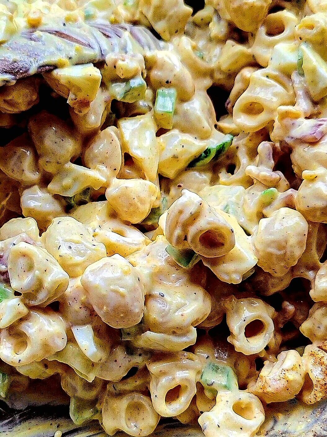 Close up of the mixing of a Mimosa Egg Pasta Salad