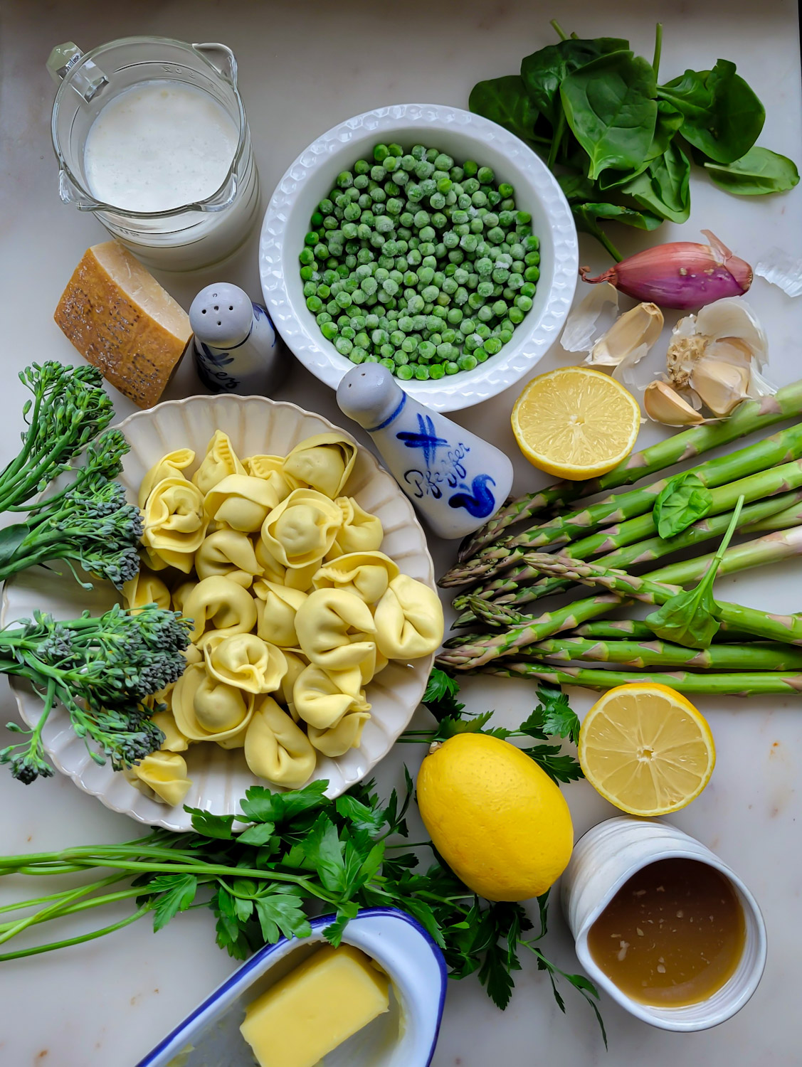 All the ingredients needed to make Lemon Cream Pasta with Spring Vegetables are spread out on the counter.