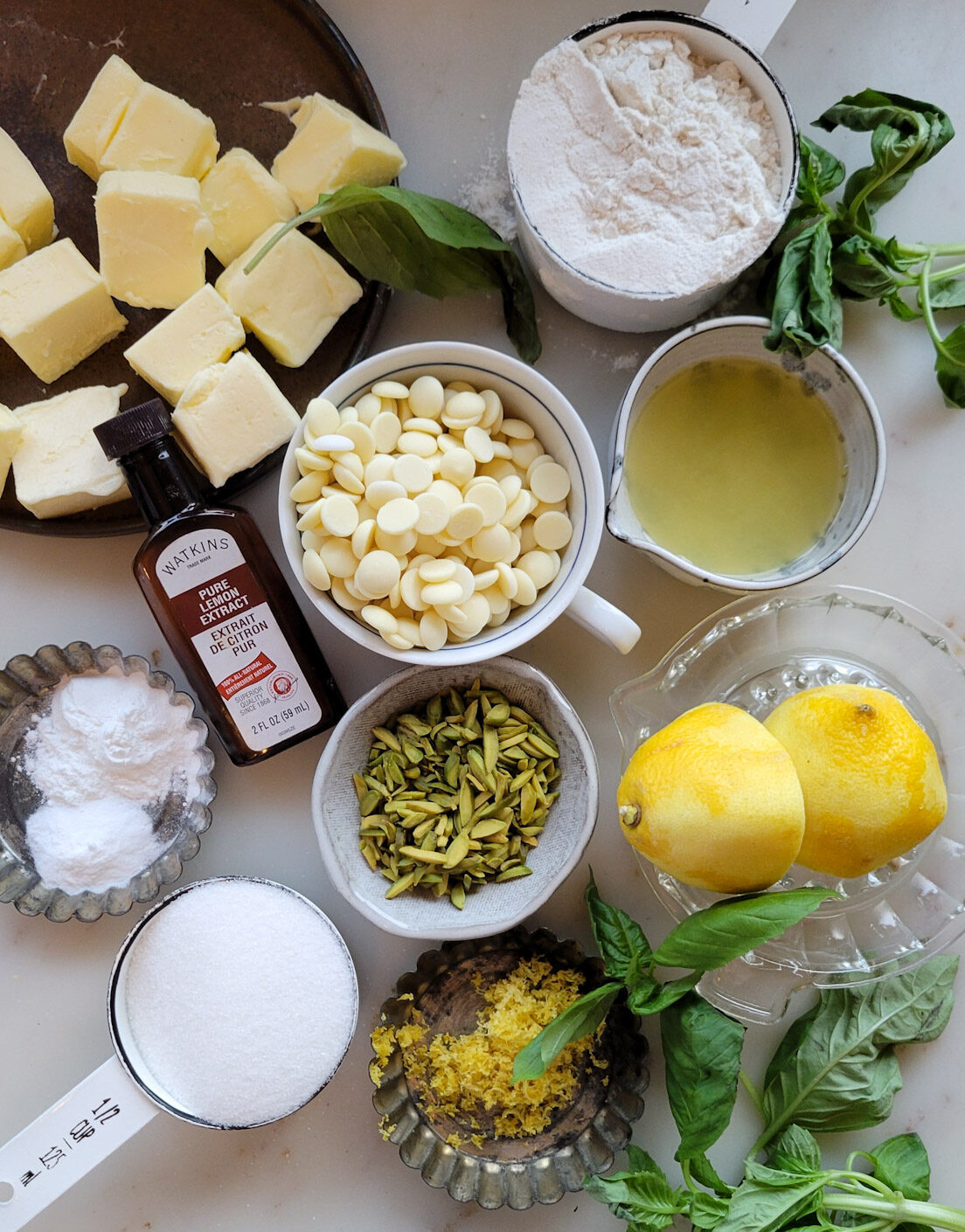 Ingredients for making Lemon Basil Cookies with White Chocolate and Pistachios are spread out on the counter.
