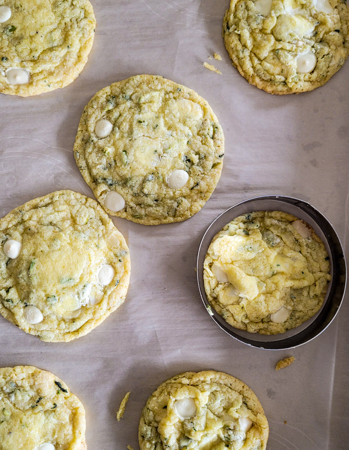 Spinning a biscuit cutter around freshly baked Lemon Basil Cookies with White Chocolate and Pistachios to make them round.