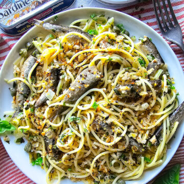 Close up of a plate of Sardine and Lemon Pangrattato Pasta, with a tin of sardines to the side.