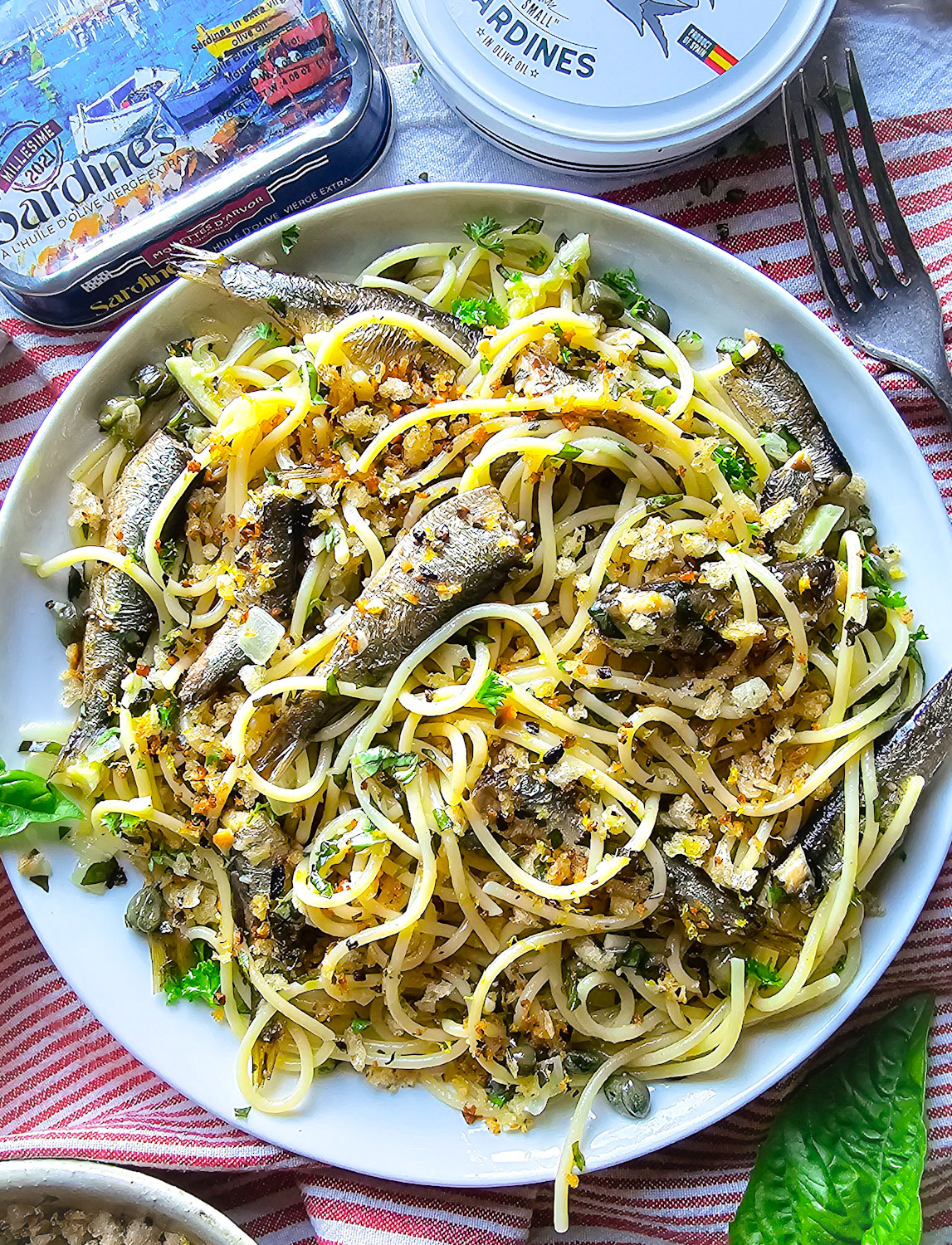 Close up of a plate of Sardine and Lemon Pangrattato Pasta, with a tin of sardines to the side.