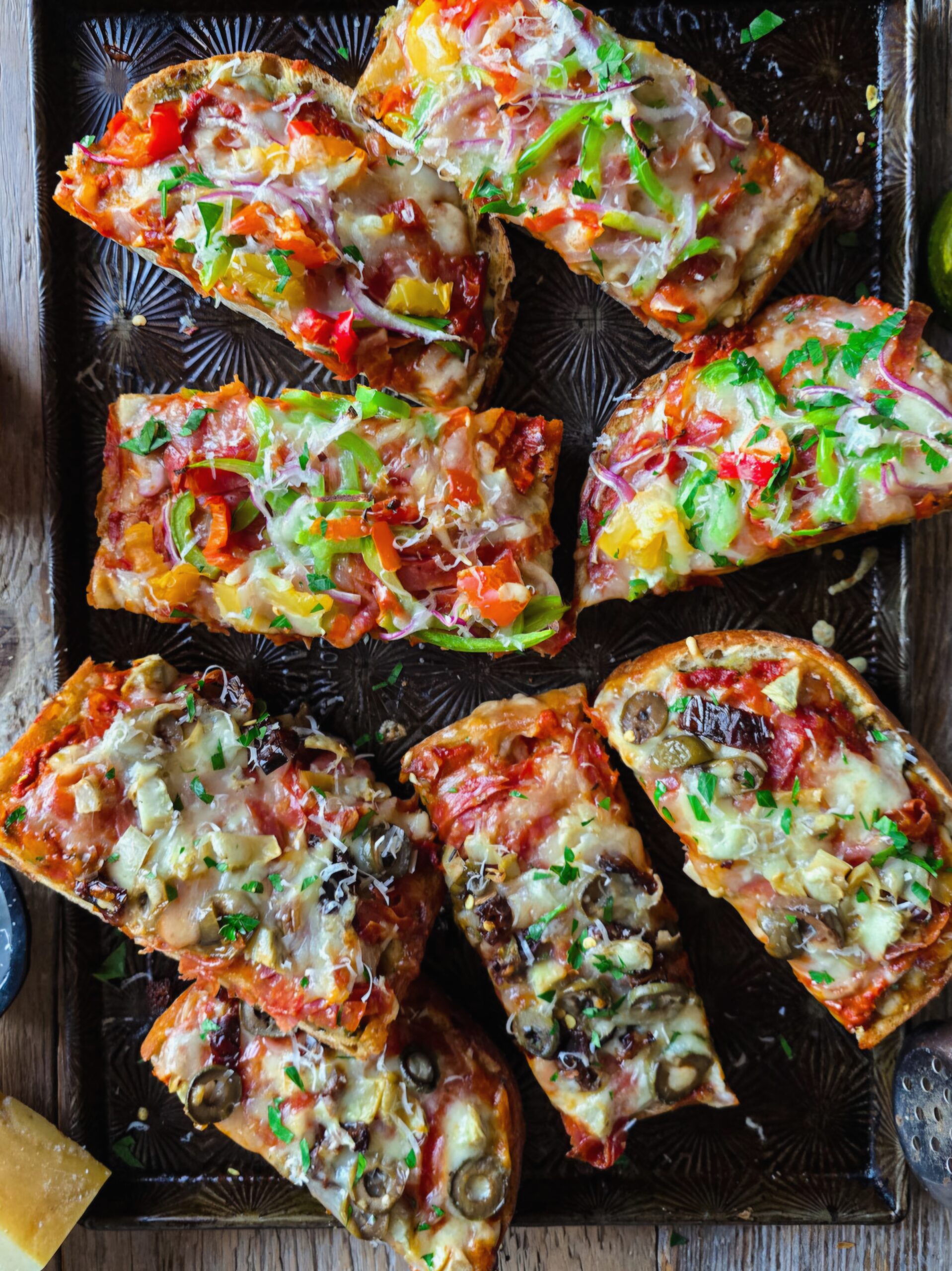 French Bread Pizza cut into pieces sitting on a baking sheet.