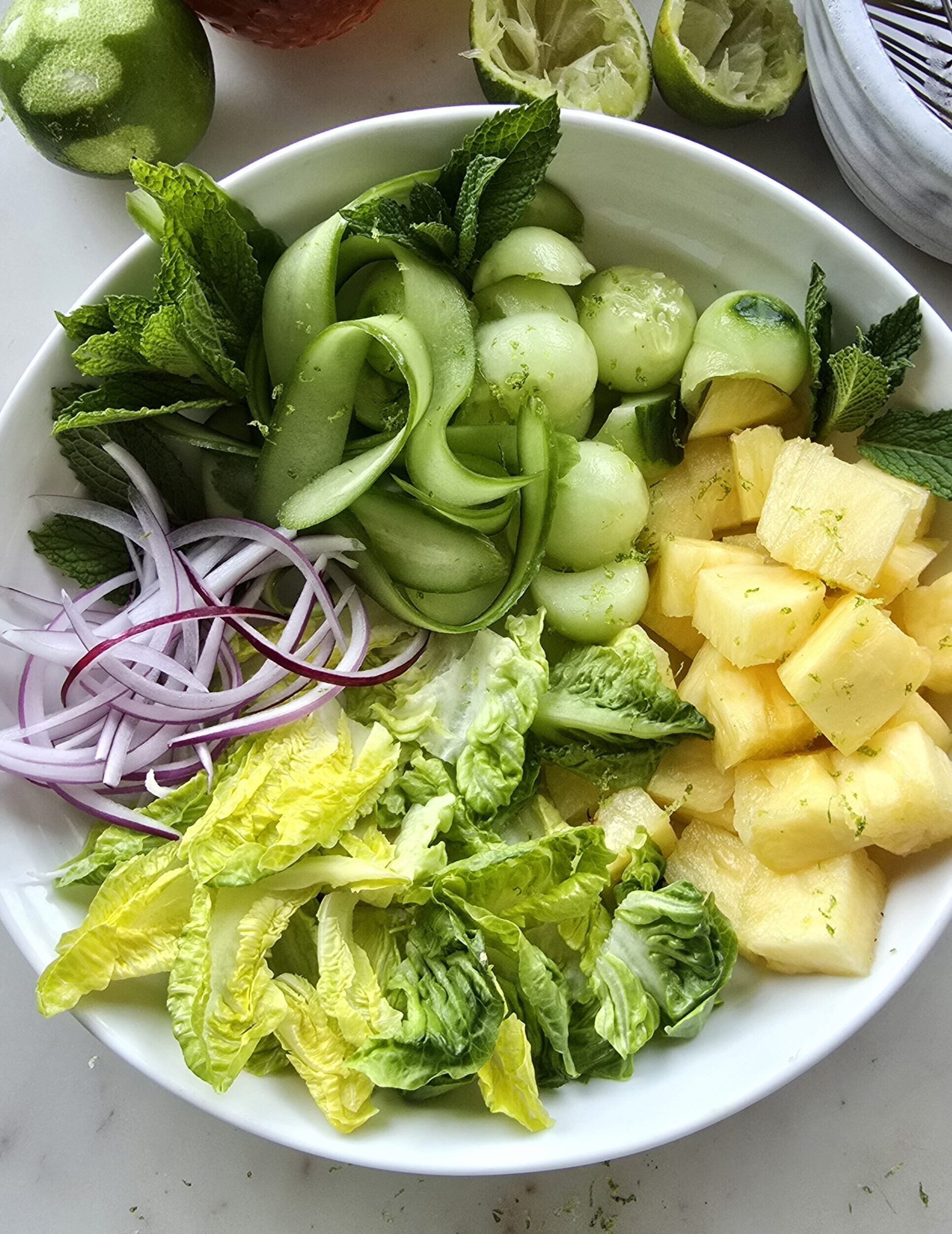 Pineapple Cucumber Salad with Mint in a bowl ready to be dressed with Hot Honey Vinaigrette