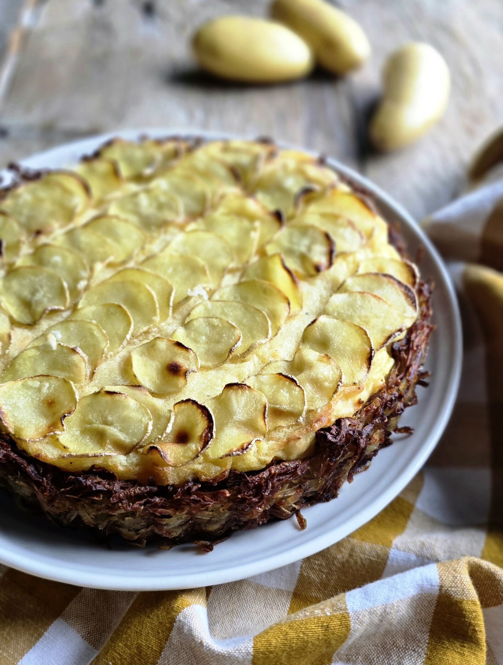 Potato Pie sitting on a plate is getting ready to be sliced up.